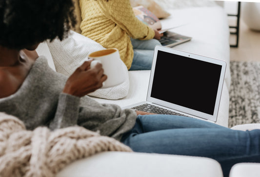 Woman working on a laptop at a bright desk, representing how to start selling PLR and MRR digital products online